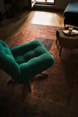 a living room with a green chair and a table at Ikigai Penthouse Apartment in Banja Luka