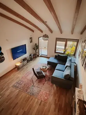 a living room with a blue couch and a tv at Ikigai Penthouse Apartment in Banja Luka