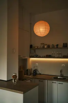 a kitchen with an orange light hanging over a counter at Ikigai Penthouse Apartment in Banja Luka