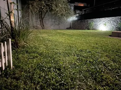 a grassy yard at night with a white fence at Studio apartman Bišće in Bihać