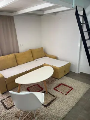 a living room with a couch and a table and a chair at Studio apartman Bišće in Bihać