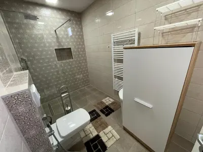 a bathroom with a shower and a toilet and a sink at Studio apartman Bišće in Bihać