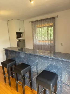 a kitchen with a counter and two stools in front of it at Lake House Ceric in Jajce