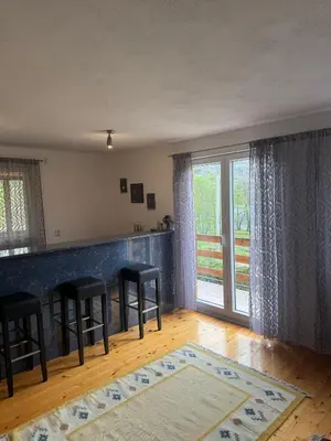 a living room with a bar with stools and a window at Lake House Ceric in Jajce