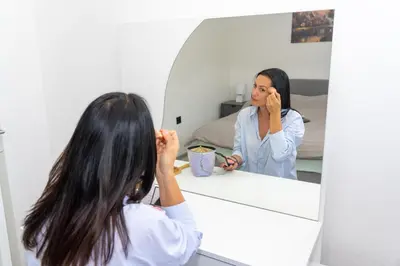 a woman looking at her reflection in a mirror at Apartman Kruna in Drvar