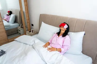 a woman sitting on a bed in a bedroom at Apartman Kruna in Drvar