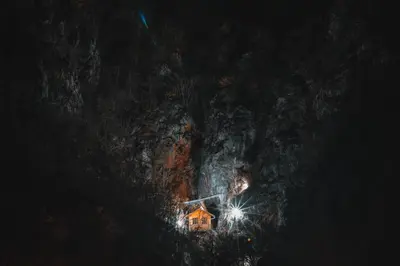a house on the side of a mountain at night at Apartman Kruna in Drvar