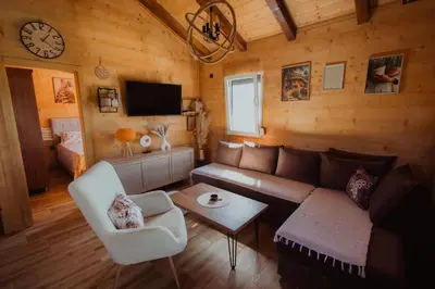 a living room with a couch and a bed and a clock at Rustic Casa in Prijedor
