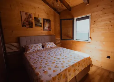a bed in a wooden room with a window at Rustic Casa in Prijedor