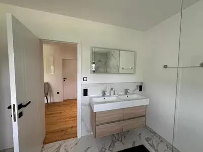 a white bathroom with a sink and a mirror at Villa Modern in Bihać