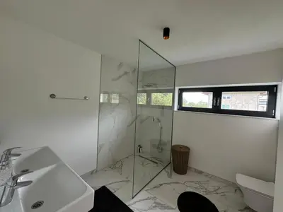 a bathroom with a glass shower and a sink at Villa Modern in Bihać
