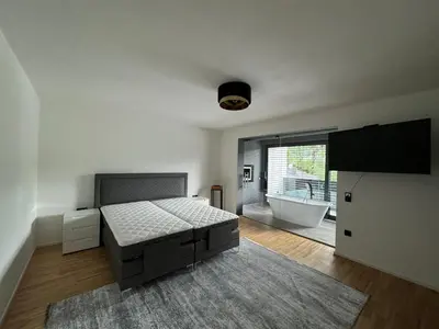 a bedroom with a bed and a bathroom with a tub at Villa Modern in Bihać
