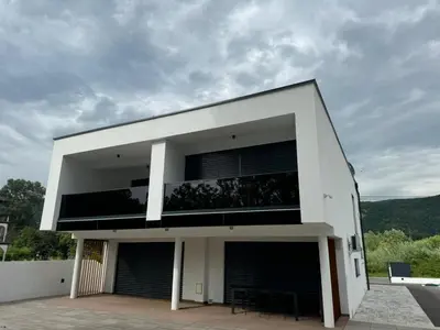 a white building with a balcony with a table at Villa Modern in Bihać