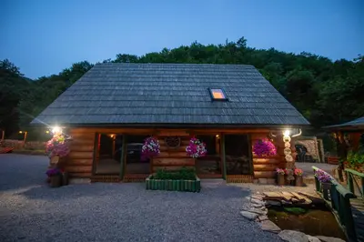 a log cabin with flowers in front of it at Villa Bosnia in Donji Vakuf