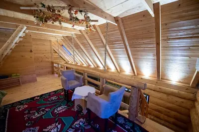 an attic room with wooden walls and blue chairs at Villa Bosnia in Donji Vakuf
