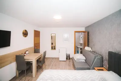 a room with a table and a couch and a dining room at Apartmani Vesto in Banja Luka