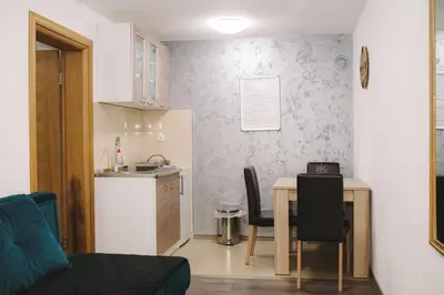 a kitchen and dining room with a table and a small kitchen at Apartmani Vesto in Banja Luka