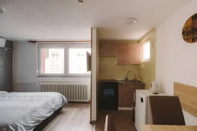 a small bedroom with a bed and a kitchen at Apartmani Vesto in Banja Luka