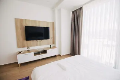 a bedroom with a bed and a television on a wall at KS Apartments in Visoko