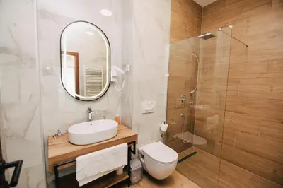 a bathroom with a toilet and a sink and a shower at KS Apartments in Visoko
