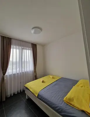 a bedroom with a bed with yellow sheets and a window at Villa AS in Bihać