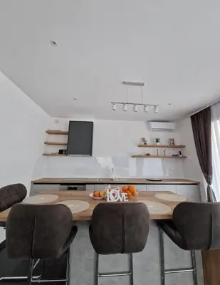 a dining room with a wooden table and chairs at Villa AS in Bihać