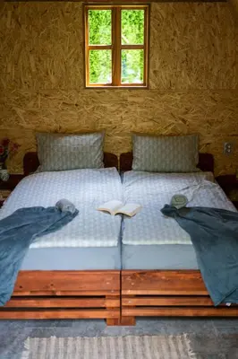 a bed with two pillows and a book on it at Moonlight & Starlight lodges in Orašac