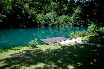 a wooden dock sitting on the side of a lake at Moonlight & Starlight lodges in Orašac