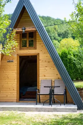 a wooden cabin with a table and a bench in it at Moonlight & Starlight lodges in Orašac