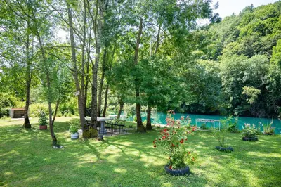 a yard with a picnic table and trees and a lake at Moonlight & Starlight lodges in Orašac