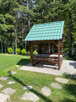 a gazebo with a green roof in a park at Villa Bella Una - Prizemlje in Cazin