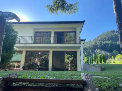 a house with a balcony on top of a yard at Villa Bella Una - Prizemlje in Cazin