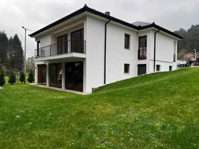 a white house on top of a green hill at Villa Bella Una - Prizemlje in Cazin