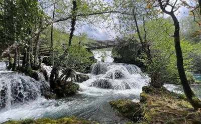 a bridge over a river with a waterfall at Apartment Alma in Bihać