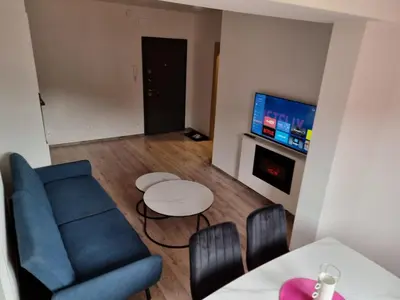a living room with a blue couch and a table at Apartman Rita in Fojnica