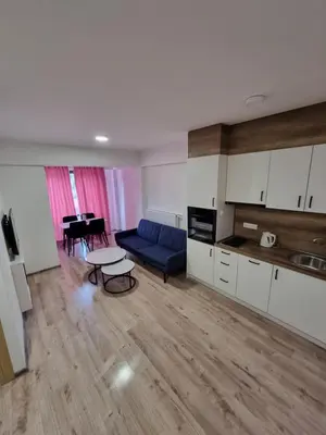 a living room with a blue couch and a table at Apartman Rita in Fojnica