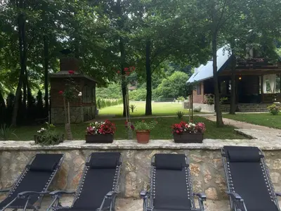 two lounge chairs on a stone wall in a yard at Holiday Home UnaPark in Krakovo