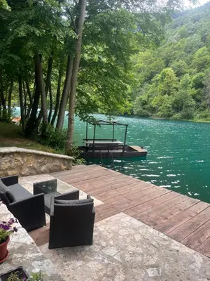 a dock with a picnic table and a boat on a lake at Holiday Home UnaPark in Krakovo