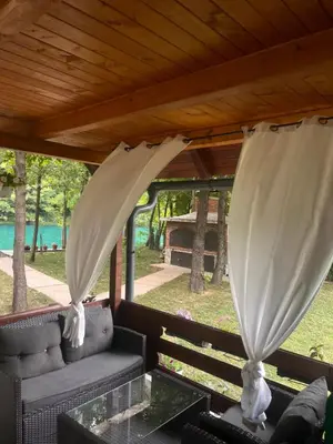 a screened in porch with a couch and curtains at Holiday Home UnaPark in Krakovo