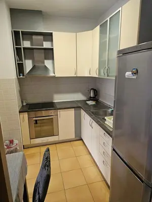 a kitchen with white cabinets and a stainless steel refrigerator at Apartman City One in Banja Luka