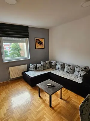 a living room with a black couch and a table at Apartman City One in Banja Luka