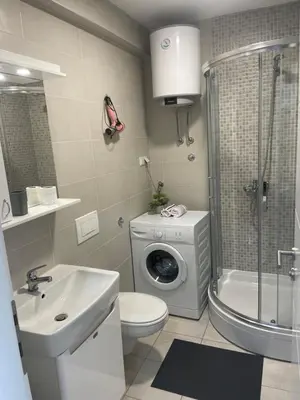 a bathroom with a washing machine and a washer at Oaza 3 in Doboj