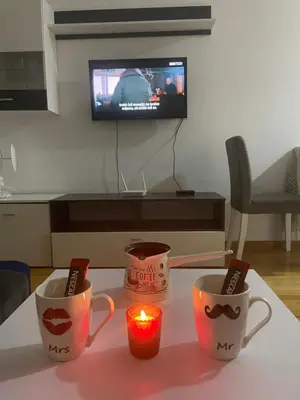 two coffee mugs and a candle on a table at Oaza 3 in Doboj