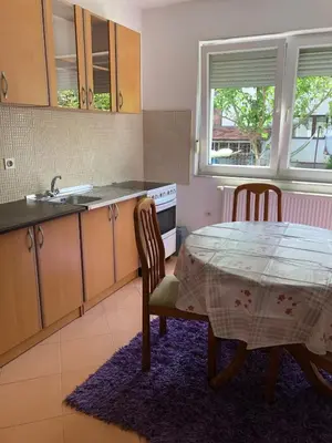 a kitchen with a table and chairs and a sink at Ema's apartments in Bihać