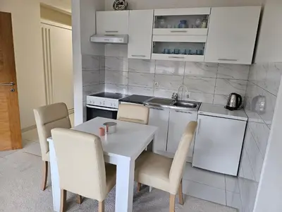 a small kitchen with a white table and chairs at Apartman Sunce in Bosanska Gradiška