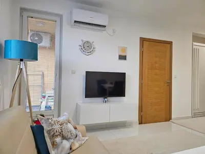 a living room with a flat screen tv on a wall at Apartman Sunce in Bosanska Gradiška