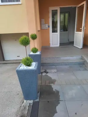 two potted plants sitting in front of a building at Apartman Sunce in Bosanska Gradiška