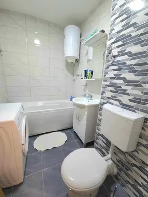a bathroom with a toilet and a sink and a tub at Apartman Sunce in Bosanska Gradiška