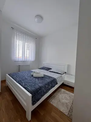 a bedroom with a bed in a white room at BL Soul Apartment in Banja Luka