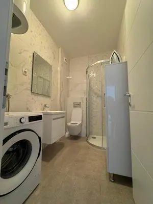 a bathroom with a washing machine and a toilet at BL Soul Apartment in Banja Luka